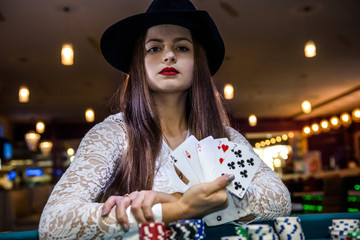 Female hand with playing cards and poker chips close up
