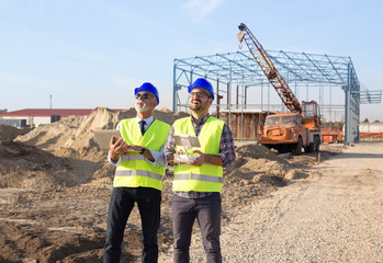 Construction engineers with drone at building site