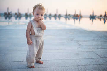 A small toddler girl standing on beach on summer holiday. Copy space.