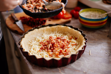 The process of making French quiche. Ingredients pie quiche. French quiche with cheese, spinach, mushrooms, bacon, dried tomatoes. Cooking.