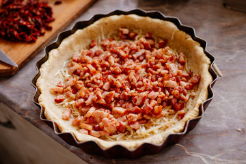 The process of making French quiche. Ingredients pie quiche. French quiche with cheese, spinach, mushrooms, bacon, dried tomatoes. Cooking.