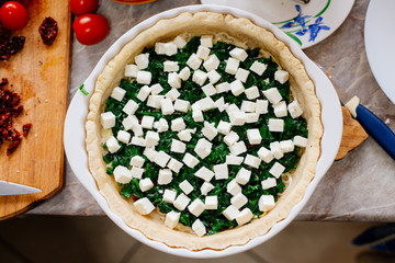 The process of making French quiche. Ingredients pie quiche. French quiche with cheese, spinach, mushrooms, bacon, dried tomatoes. Cooking.