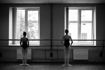 Ballerina doing stretching in the dance hall. Close-up of a ballerina in the dance hall. Black and...