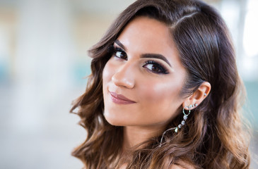 Close up portrait of beautiful teen girl getting ready for her prom. Glamorous hairstyle and long silver earrings © stivog