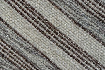 Background of knitted natural wool in dark white, brown and grey colours in diagonal display