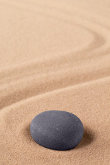 Fototapeta na wymiar Zen meditation stone to focus and concentrate for a quit peace of mind. Spiritual raked sand background texture. Concept for harmony purity and spirituality.