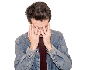 Portrait of  despair young man closed face by two hands. Isolated on a white background.