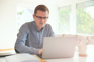Young freelancer working with laptop at home