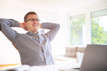 Naklejka premium Young freelancer working with laptop at home