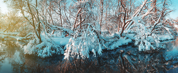 Frosty winter landscape with snow covered trees and river