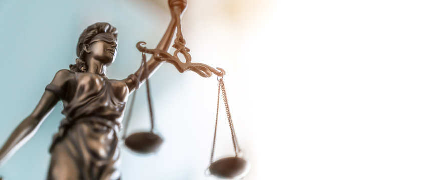 Statue of lady justice on bright background - Side view with copy space.