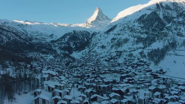 Zermatt Village and Matterhorn Mountain at Sunny Winter Day. Switzerland. Aerial View. Reveal Shot. Drone Flies Forward, Camera Tilts Up