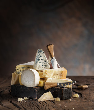 Assortment of different cheese types on wooden background. Cheese background.