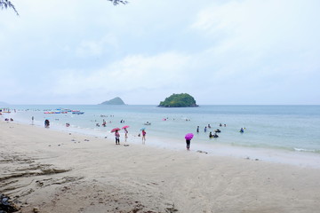 Travelers visiting the beach and playing in the sea on a rainy day