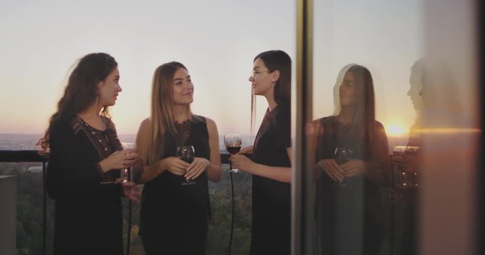 On the penthouse balcony at the home party ladies drinking wine and spending a great time together