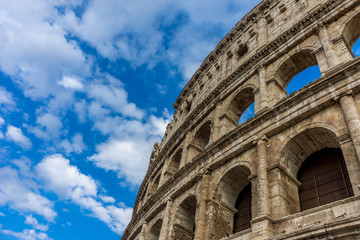 Fototapeta premium Facade of the Great Roman Colosseum (Coliseum, Colosseo), also known as the Flavian Amphitheatre. Famous world landmark. Scenic urban landscape.
