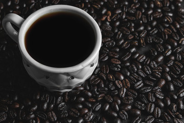cup of coffee with beans on black background