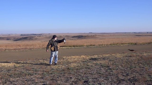 Man and Hawk Eagle train in arid grassland shot in slow motion