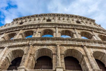 Facade of the Great Roman Colosseum (Coliseum, Colosseo), also known as the Flavian Amphitheatre. Famous world landmark. Scenic urban landscape.