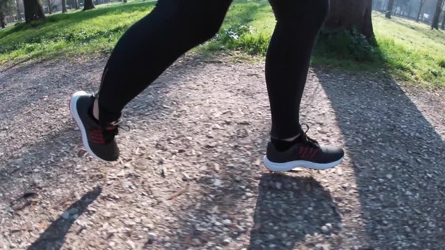 Gambe donna con scarpe da corsa che corre nel parco