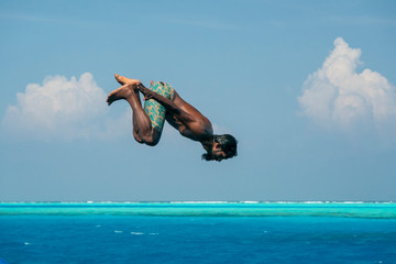 maldivian man diving from boat