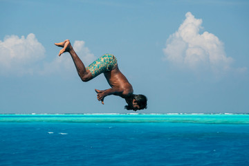 maldivian man diving from boat