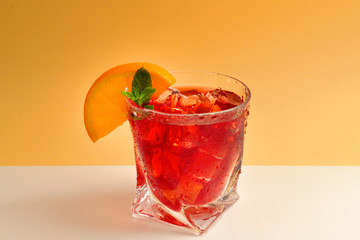 Red fresh drink with ice, grapefruit and mint on an beige background. Space for text or design.