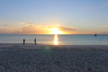 Fototapeta na wymiar Some children at sunset in the Blue Lagoon Beach in Nacula Island, Yasawa, Fiji