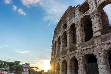 Golden sunset at the Great Roman Colosseum (Coliseum, Colosseo), also known as the Flavian Amphitheatre. Famous world landmark. Scenic urban landscape.