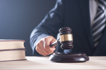 Hand of a judge holding a hammer or gavel