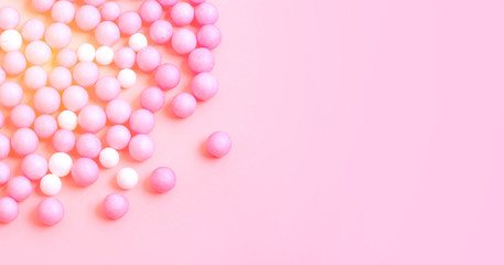 Pink and white small balls are scattered on the pink surface