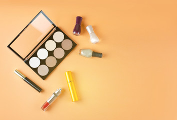 Cosmetics lies on a soft peach background. Contents of women's cosmetic bag