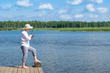 fisherman on the bank fishes on spinning on the river