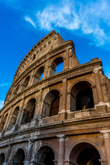 Fototapeta premium Golden sunset at the Great Roman Colosseum (Coliseum, Colosseo), also known as the Flavian Amphitheatre. Famous world landmark. Scenic urban landscape.