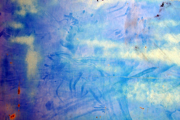 Pared blanca con marcas de dedos, óxido y pintura violeta y azul