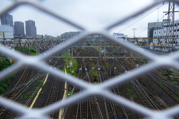 View on railroad in Asakusa, Tokyo, through a wire mesh fence from a bridge, Japan