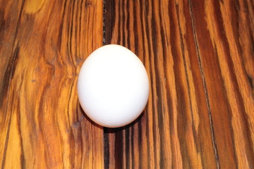 white egg lay on treated wooden boards