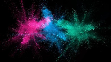 Super slowmotion shot of color powder explosions isolated on black background.
