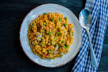 Lentil porridge with vegetables and herbs. Healthy lifestyle. Dietary menu. Dark wooden background. View from above.