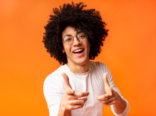 Cheerful man in spectacle indicating happily at you