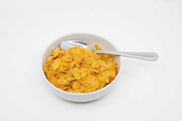 Bowl of corn flakes with a spoon inside
