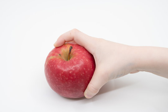 Childs Hand Holding A Red Apple