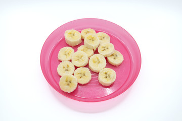 Sliced banana on a pink plastic plate