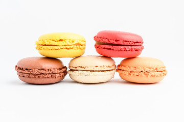 Five sweet French macarons isolated on white, flavours of strawberries,  lemon, caramel, vanilla and chocolate,  pastel colors