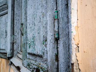 The closed gray windows. Rusty loops with a set of paint coats