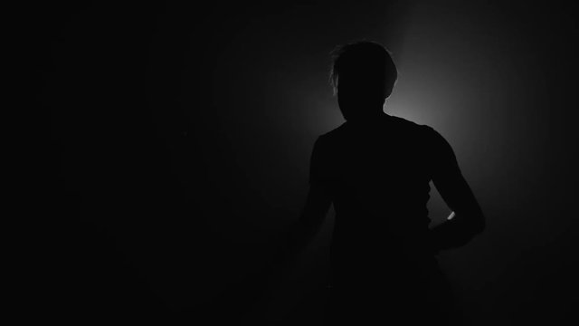 Silhouette of man playing squash