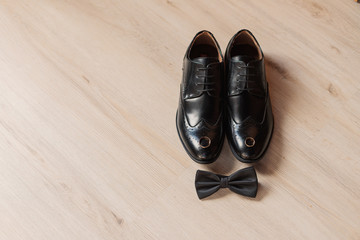 Shoes and a butterfly on a wooden floor, men's wedding accessories.