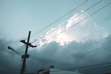 Electricity post and cloudy sky from low angle view