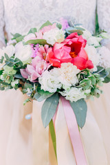Woman holding colorful bouquet with her hands on wedding day. Bright flowers