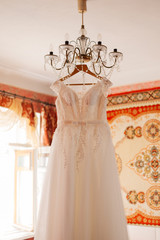 Wedding dress on the chandelier in the room.